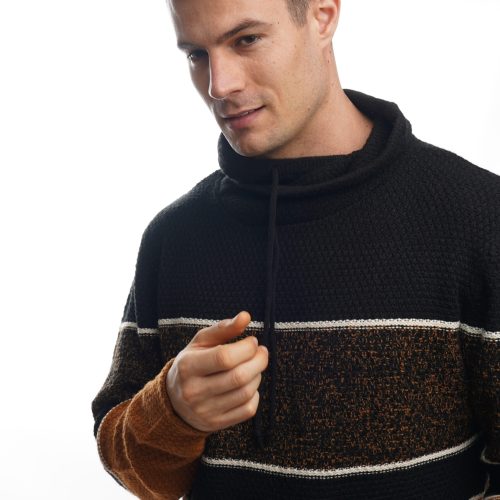 A closeup portrait of a young male wearing a warm striped sweater and posing against a white background