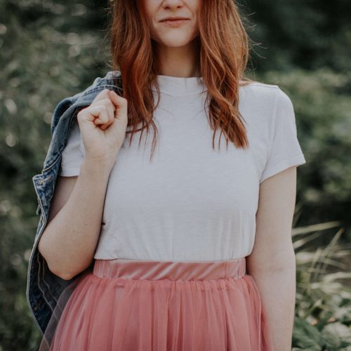A young girl in a beautiful dress and denim jacket