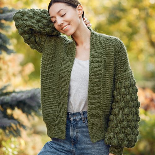 Girl in a summer park. Woman in a knited sweater.